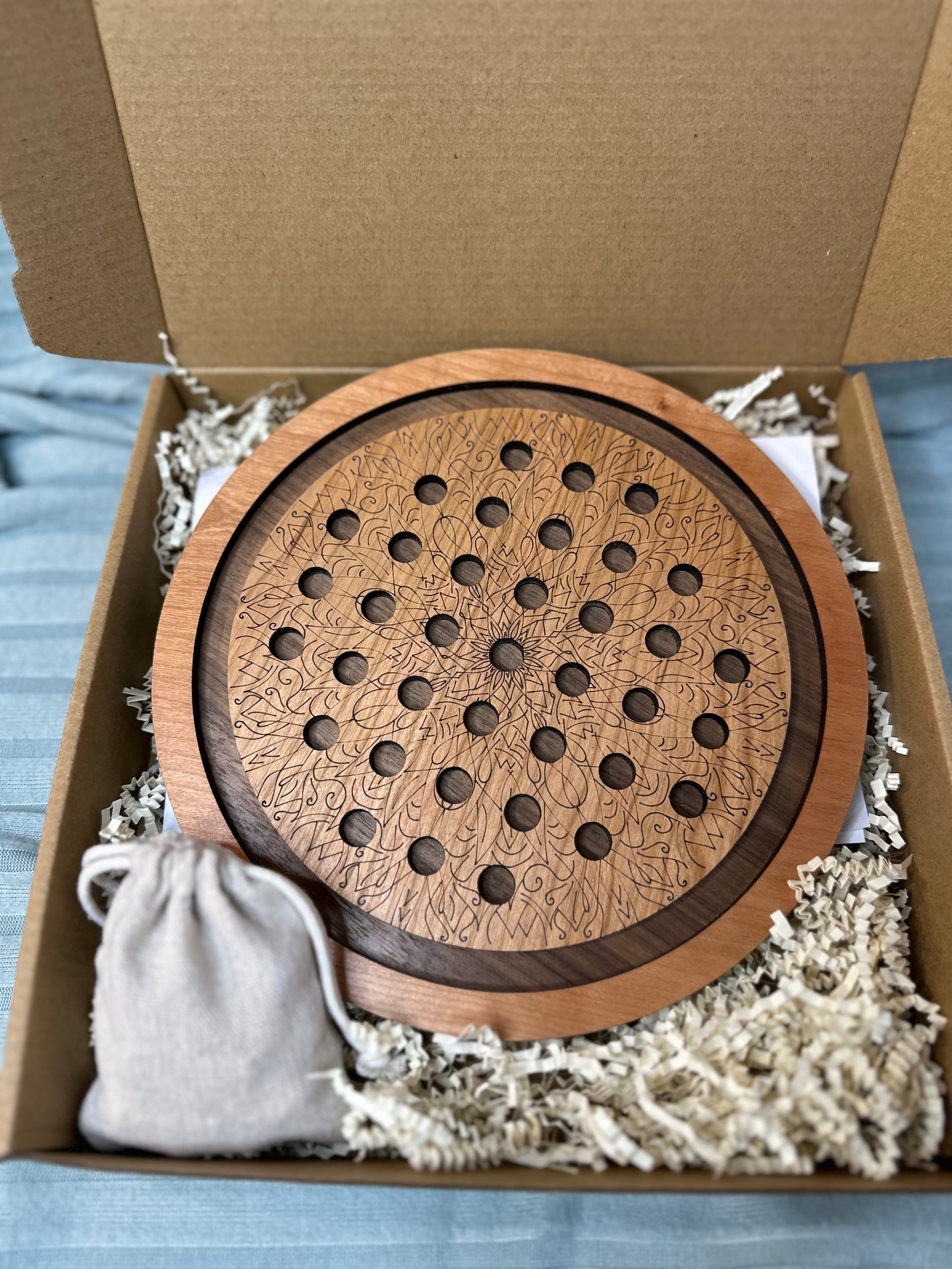 Our Cherry and Walnut marble solitaire board packaged up ready for shipment. Includes a linen drawstring bag (shown) for marble storage.