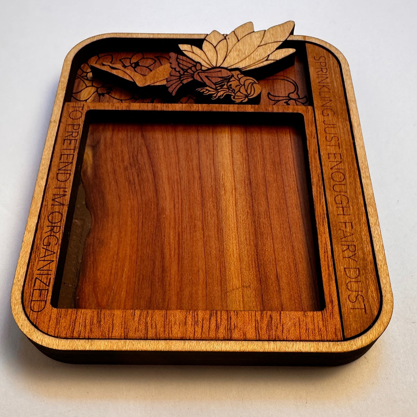 Wooden noteholder with laser-cut designs inside view and text on a light gray background