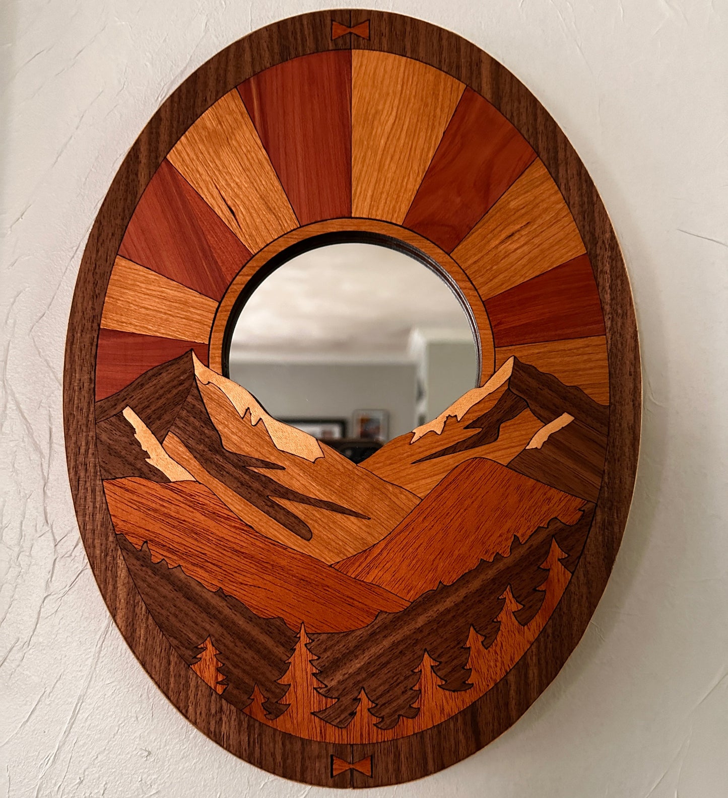 Wooden circular mirror with a geometric design on a white wall