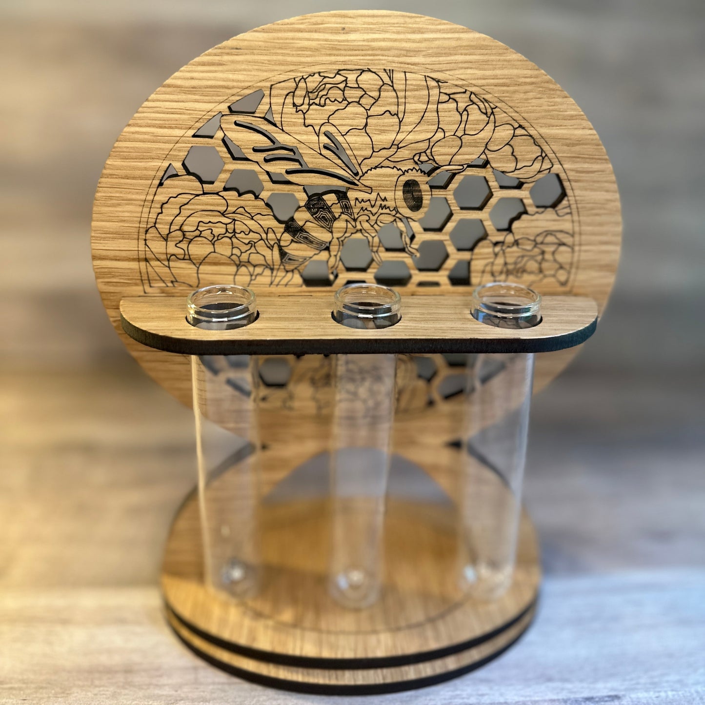 A wooden bee and peony propagation station with glass tubes for plant cuttings. Shown in Oak.