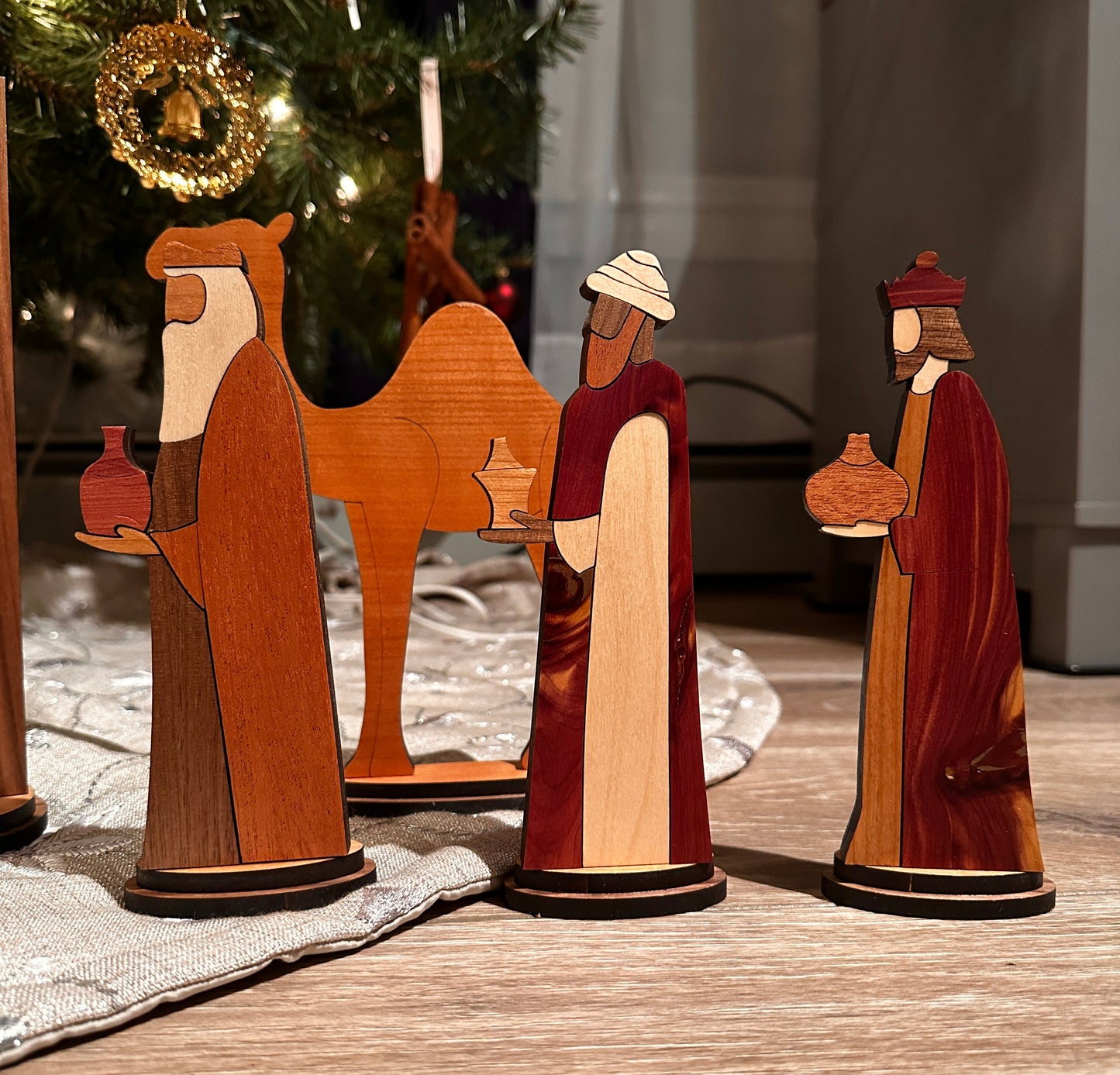 Wooden nativity scene three wisemen and camel on a wooden surface with a blurred background