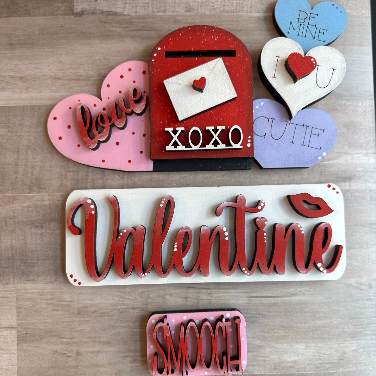 This is our Valentine insert that goes with our Vintage Truck. It shows a heart with the word love, a cute vintage mailbox with an envelope sealed with a heart and xoxo on the bottom of the mailbox, as well as three stacked hearts that read Be Mine, “I (heart symbol) U” and “cutie” which slide into the back of the truck's rails. The tailgate reads “Valentine”, and the license plate reads “Smooch”. Hand painted