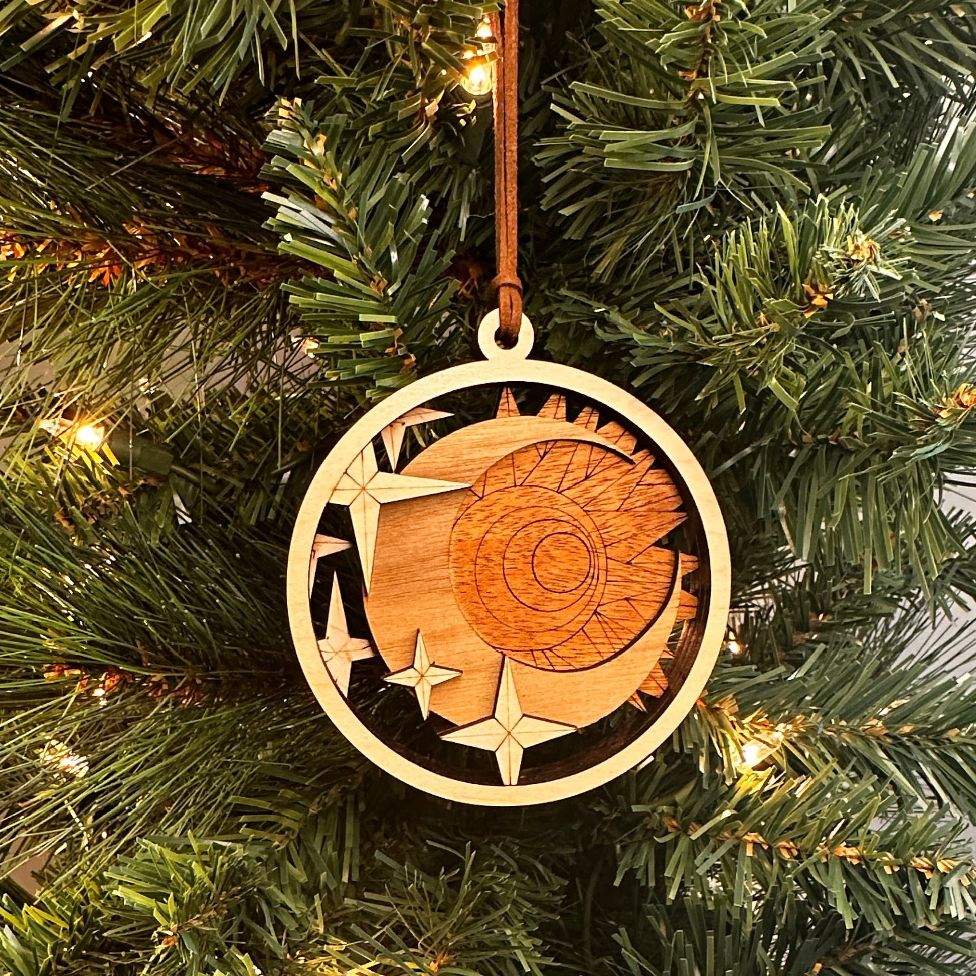 Layered wooden ornament with sun, moon and stars. Made with multi species of wood.  