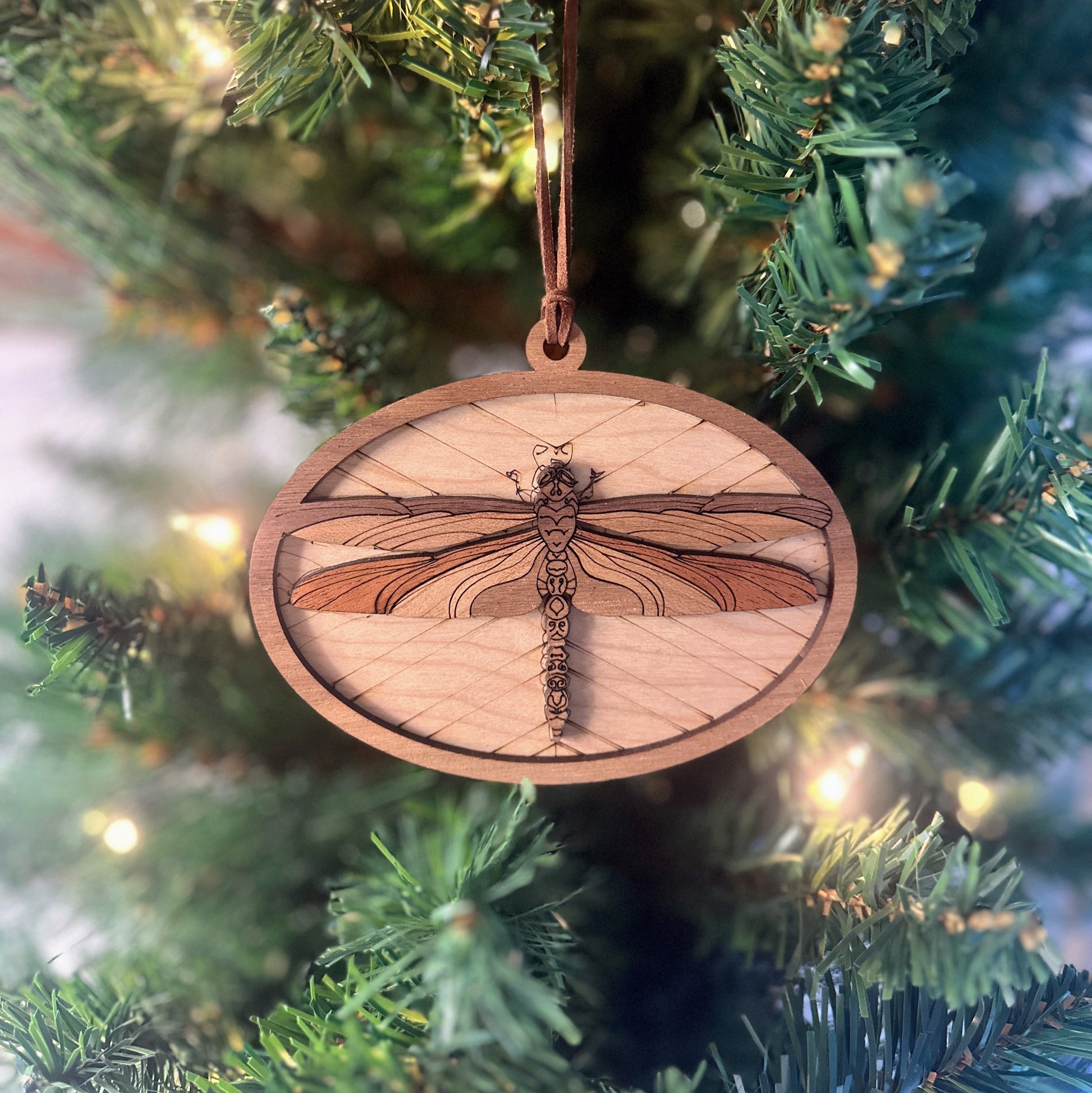 Wooden dragonfly ornament hanging on a Christmas tree