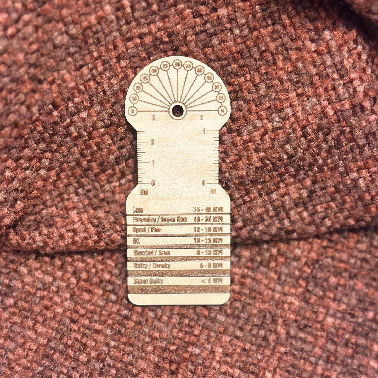 Wooden WPI measuring tool on an orange and rust blanket.